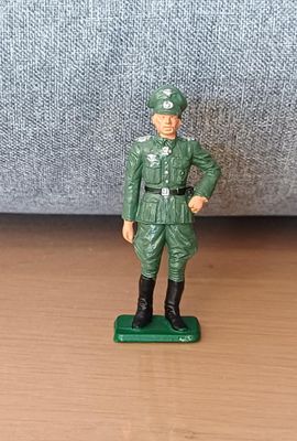 figurine représentant un homme en uniforme vert, debout sur un socle vert