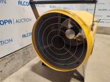 a yellow fan sitting on a stand in front of a wall