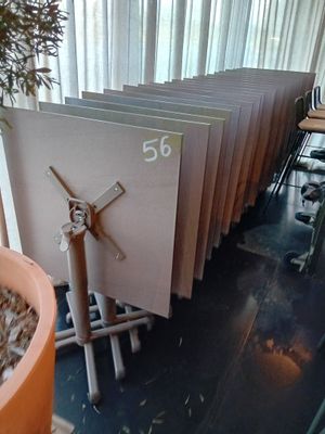une horloge accrochée au mur à côté d'une plante en pot