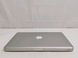 a silver apple laptop computer sitting on a white surface