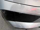 a close up of a car ' s front bumper with a cat on it