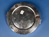 a silver plate on a blue surface with a tag on it