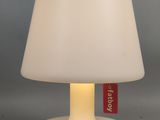 la lampe est blanche et porte une étiquette rouge