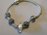 bracelet plaqué argent orné d'une perle en verre et de breloques