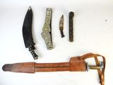 a knife, knife sharper, and other tools laid out on a white surface
