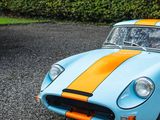 a blue and orange sports car parked in a parking lot