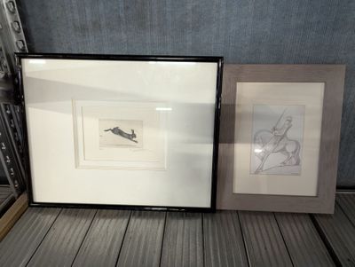 two framed pictures on the floor next to each other