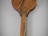 an old wooden paddle with a wooden handle sitting on a white surface