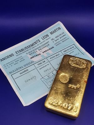 un gros plan sur un morceau d'or à côté d'un ticket de caisse