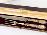 a knife, fork and spoon in a box on a table