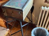 une valise posée sur une table, à côté d'une poubelle