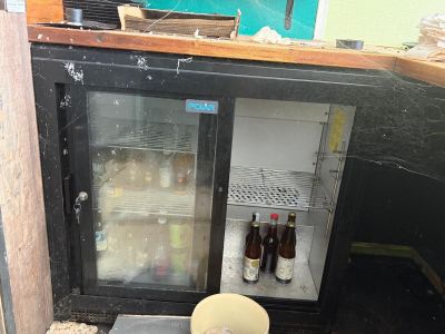 a small refrigerator with bottles of beer inside of it