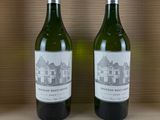 two bottles of wine sitting on top of a wooden shelf