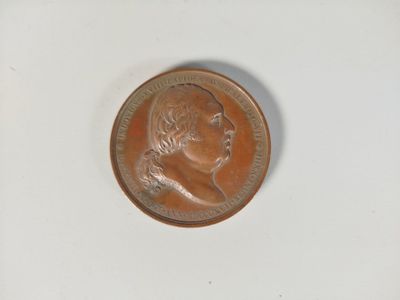 une petite pièce sur laquelle figure l'effigie d'un homme