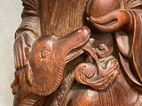 an image of a wooden statue of a man holding a bird