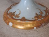 a white and gold vase sitting on a table