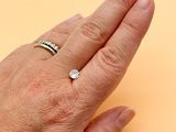 a woman ' s hand with a diamond ring on it