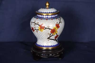 un vase orné d'un motif floral, posé sur un socle