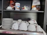 many cups and mugs on a shelf in a kitchen