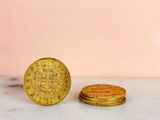 two gold coins sitting on top of a marble counter top