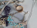 many different types of necklaces and bracelets laid out on a table