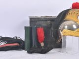 a helmet with a red feather on top of it next to a suitcase