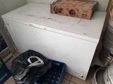 un réfrigérateur blanc dans un coin d'une pièce, avec une boîte posée dessus