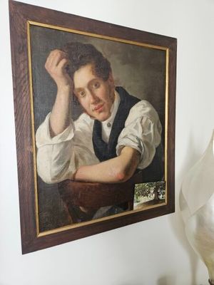 a picture of a painting on the wall above a lamp
