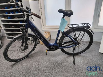 un vélo garé dans une pièce, à côté d'une pile de cartons