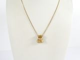 a gold plated necklace with a small glass bead on a gold chain