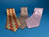 three different colored ties on a blue surface with a blue background