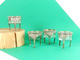quatre coupes en argent posées sur un socle en bois