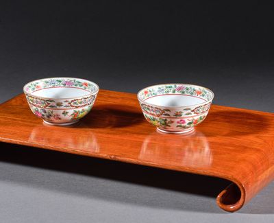 une paire de bols en porcelaine chinoise posés sur un plateau en bois, sur fond gris