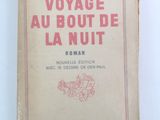 un vieux livre posé sur une table blanche, avec une couverture rouge et rose