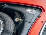 a close up of a red car with a tire on it