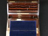 an antique silver and wood box with blue velvet inside