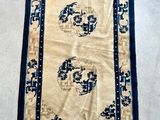 an antique chinese rug with a blue border and a white background
