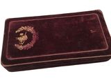 un coffret en velours orné d'un emblème doré