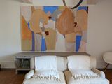 a white couch in a living room with a painting on the wall behind it