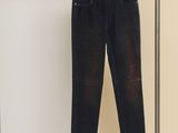 des jeans suspendus à un portant dans une pièce aux murs blancs