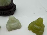 three jade figurines sitting next to each other on a table