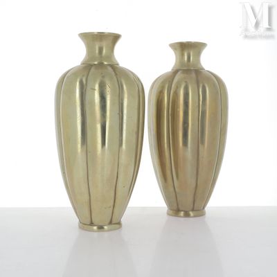 deux vases en or posés côte à côte sur une surface blanche