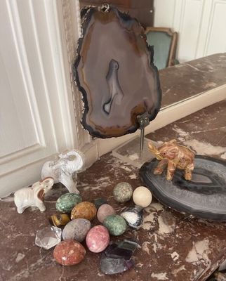a table with a mirror and some rocks and a figurine