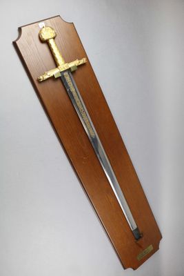 wooden plaque with a sword mounted on it on a wall