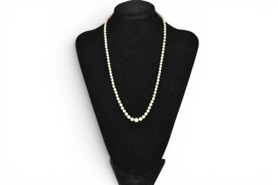 a black mannequin with a white pearl necklace on it