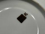 une assiette blanche sur laquelle figure un carré marron