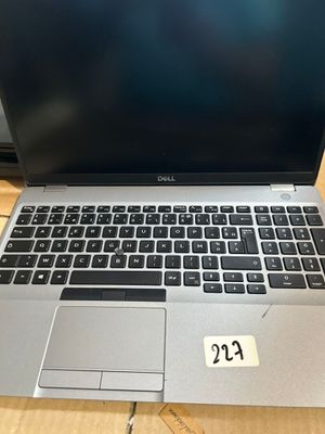 un ordinateur portable ouvert posé sur une table en bois
