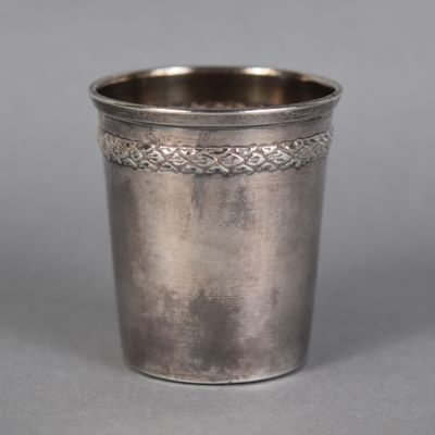 an antique silver cup with a decorative design on the rim