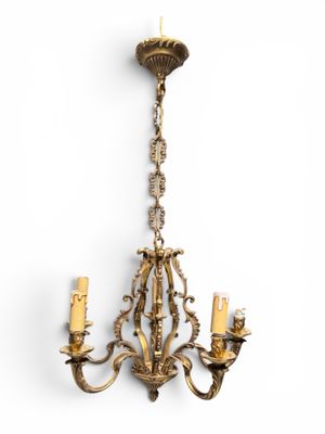 un lustre ancien en laiton à trois branches suspendu au plafond