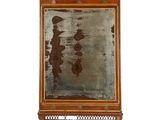 une image représentant un miroir accroché au mur, dont la surface est rouillée